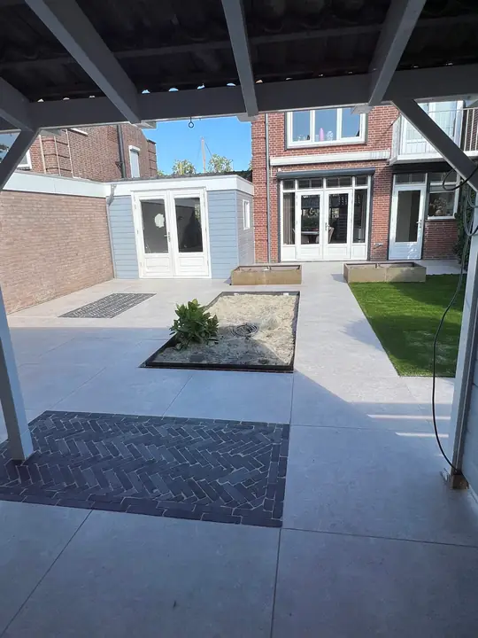 Visgraatvlak van donkere klinkers in een lichtgrijs terras