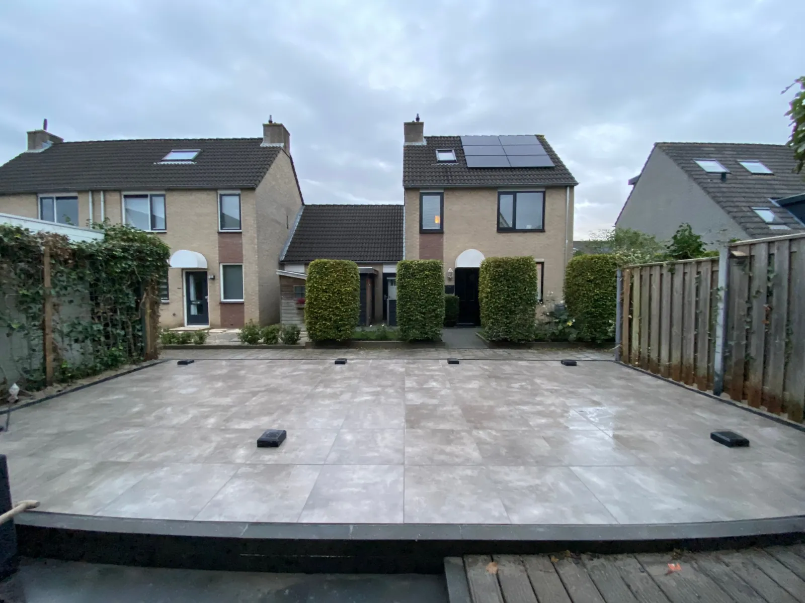 Groot verhoogd terras in lichtgrijs voor een rij woningen