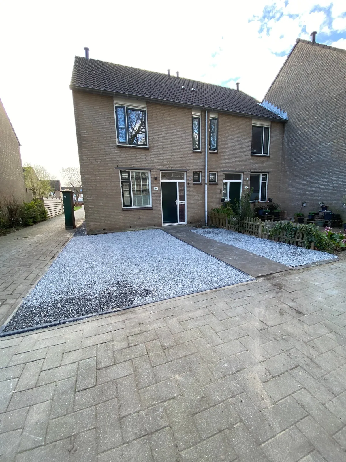 Klinkers in visgraatverband naast een strak grindvlak voor een woning