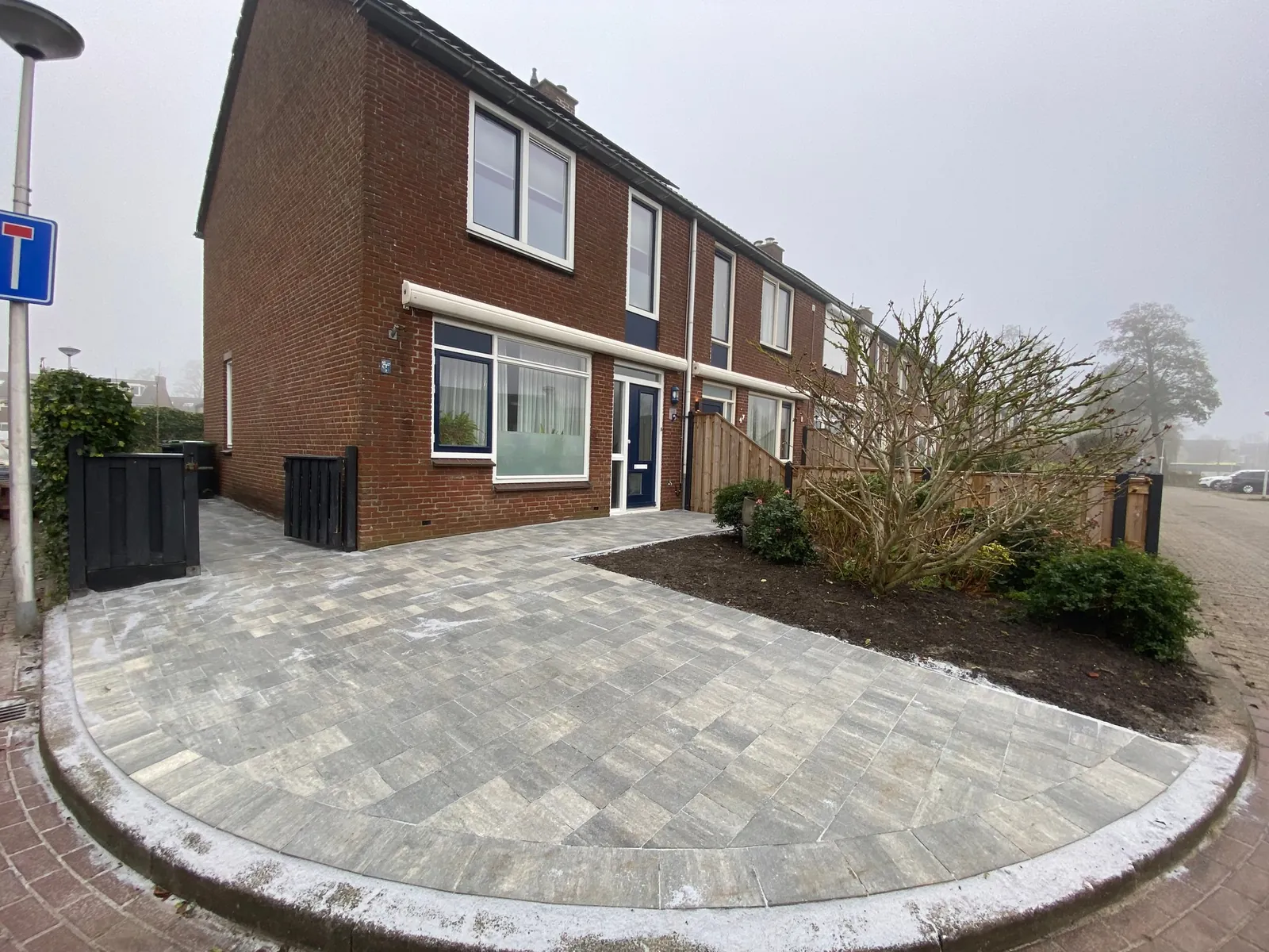 Hoekwoning met nieuwe bestrating in een ronde vorm tot aan de stoep