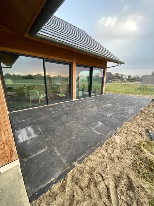 Grindpaden en terras bij houten woning